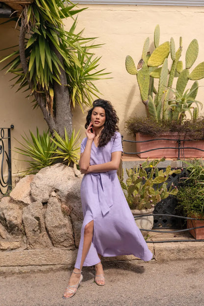 Frau trägt fließendes lavendelfarbenes Sommerkleid beim Gehen mit leichtem Stoff